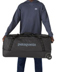 Patagonia Black Hole Wheeled Duffel Bag 100L (Black) holding sides