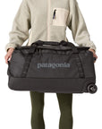 Patagonia Black Hole Wheeled Duffel 70L (Black) holding both side