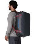 Patagonia Black Hole 55L Duffel Bag (Smolder Blue w/Amanita Red) person